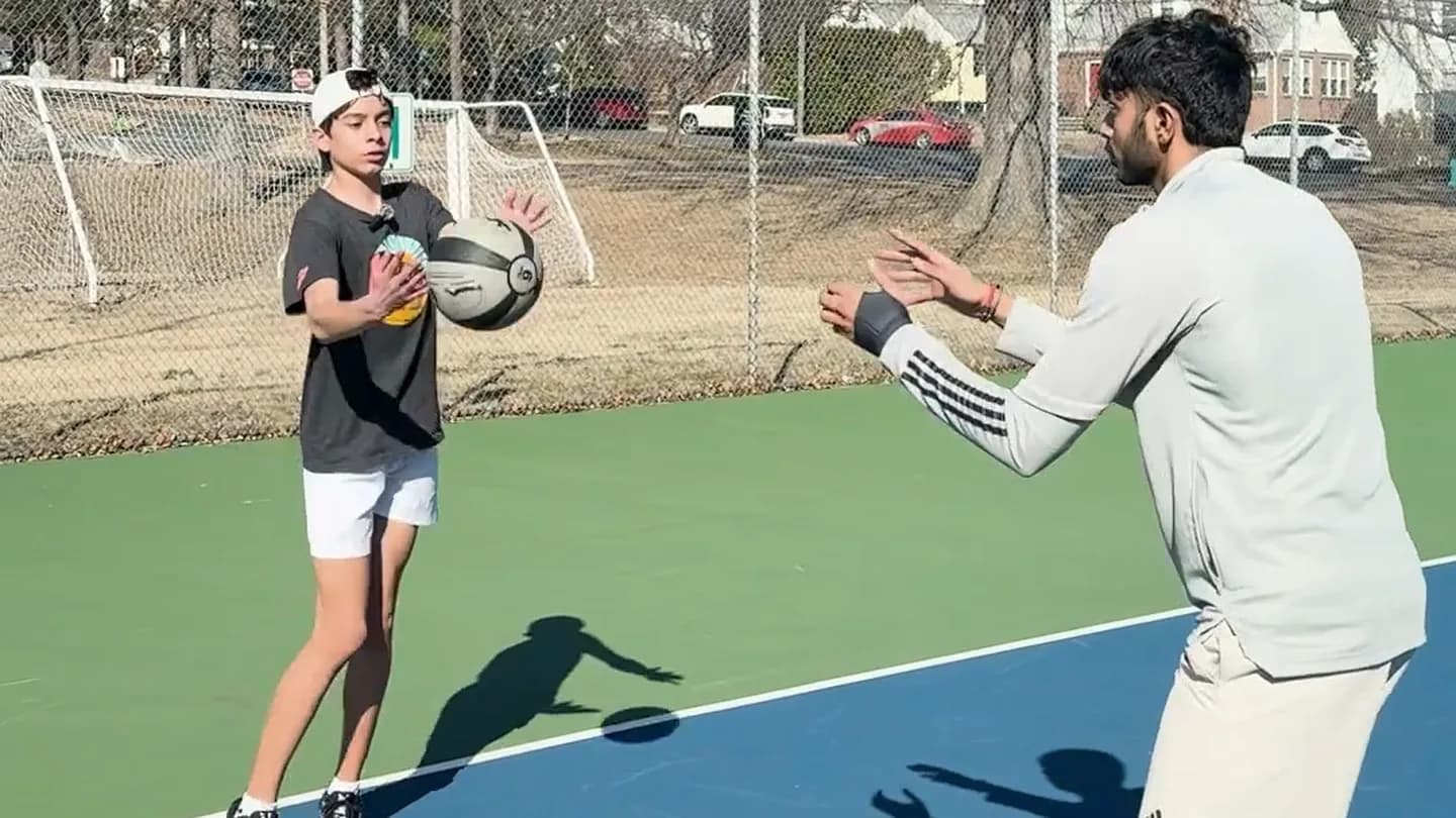 A private tennis coaching session on an outdoor court.